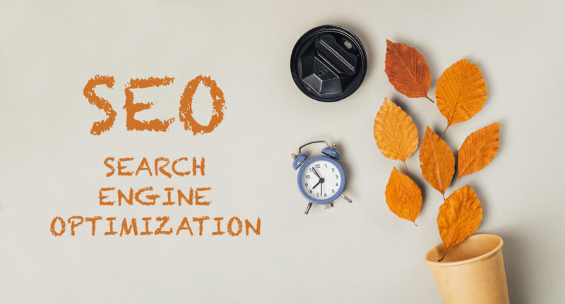 Seasonal SEO concept with clock and autumn leaves illustrating Google Business Profile holiday hours and December search optimization.